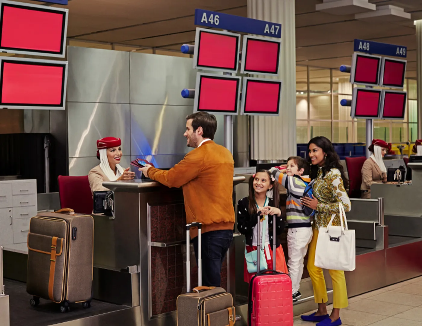 A family checking in at an Emirates airport counter